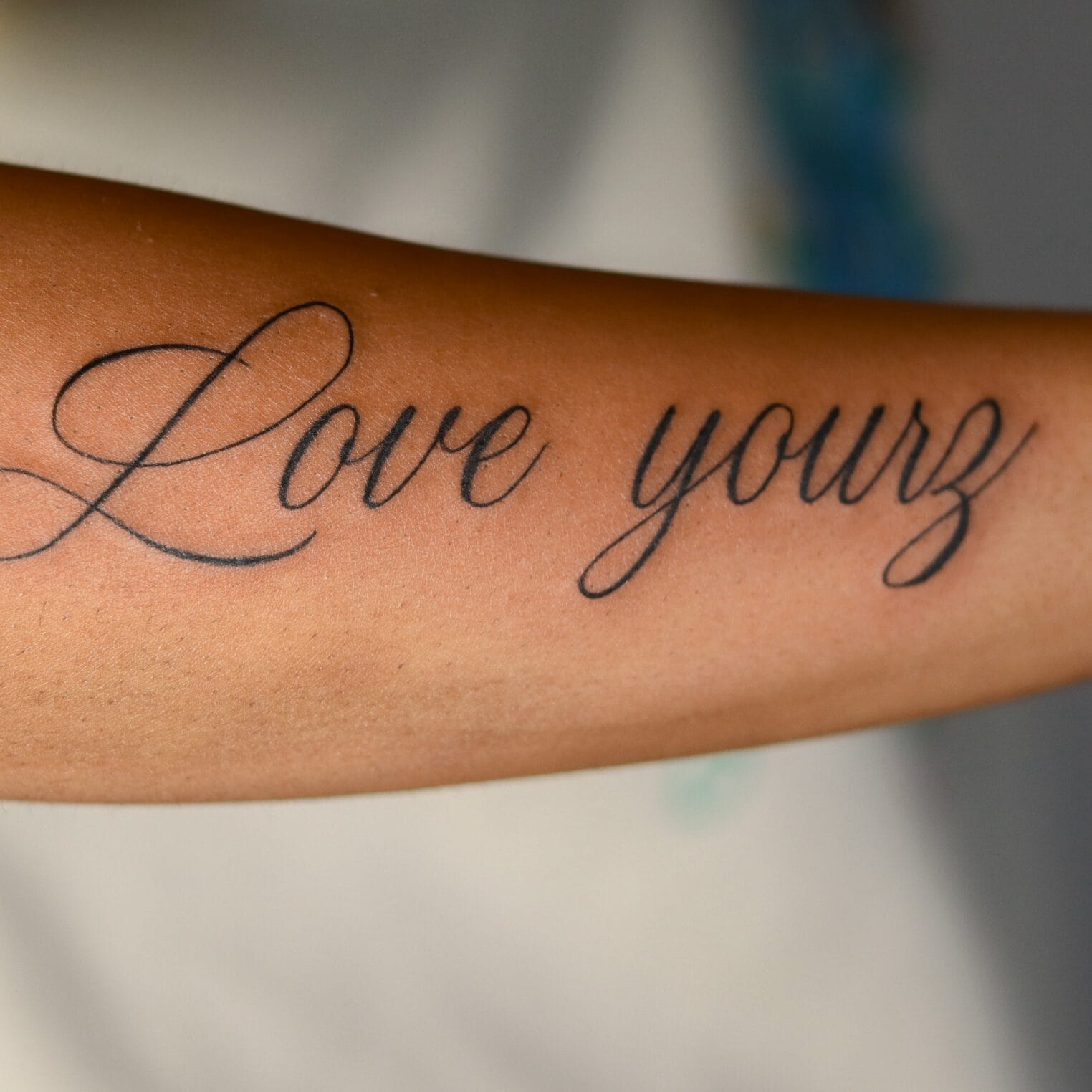 Forearm Tattoo with Large Handwritten Script