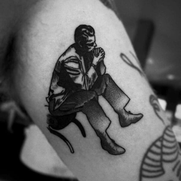 Thoughtful Man on Chair Tattoo on Bicep