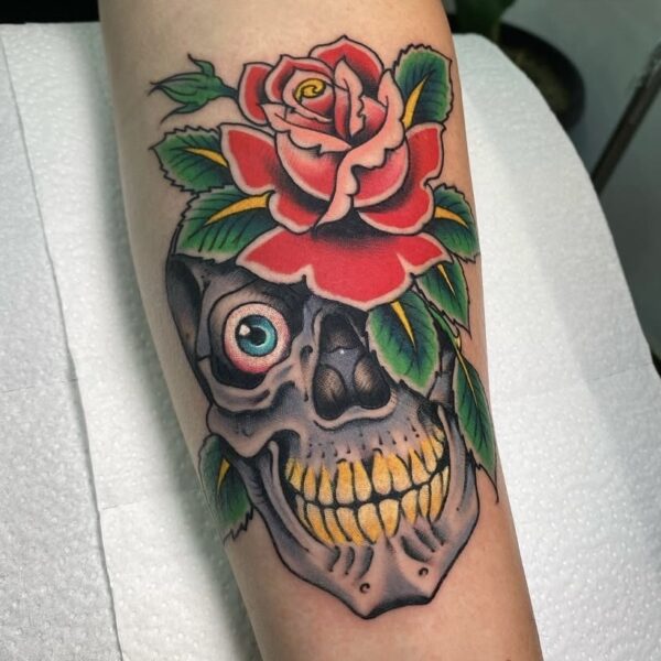 Skull and Rose Tattoo on Forearm in Traditional Style