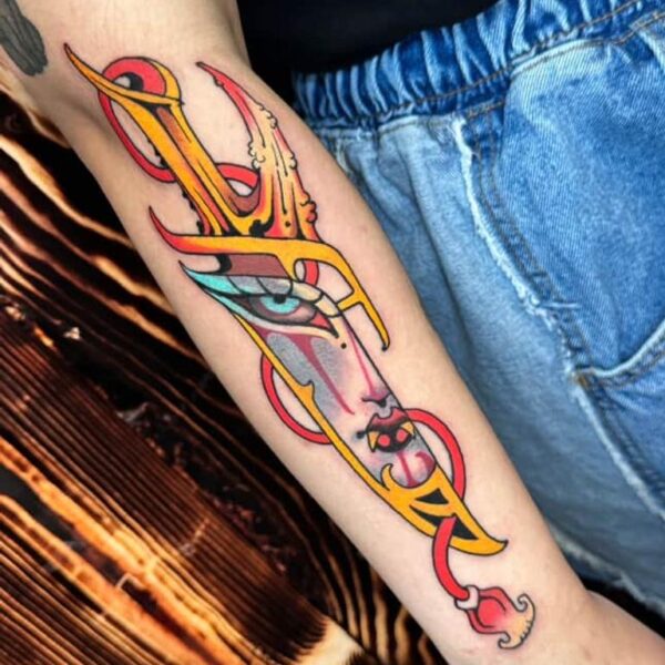 Sword and Face Tattoo on Forearm