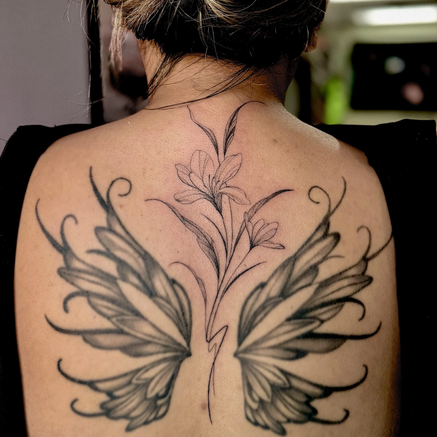 Enhancing Old Back Tattoo With a Soft Flower Design
