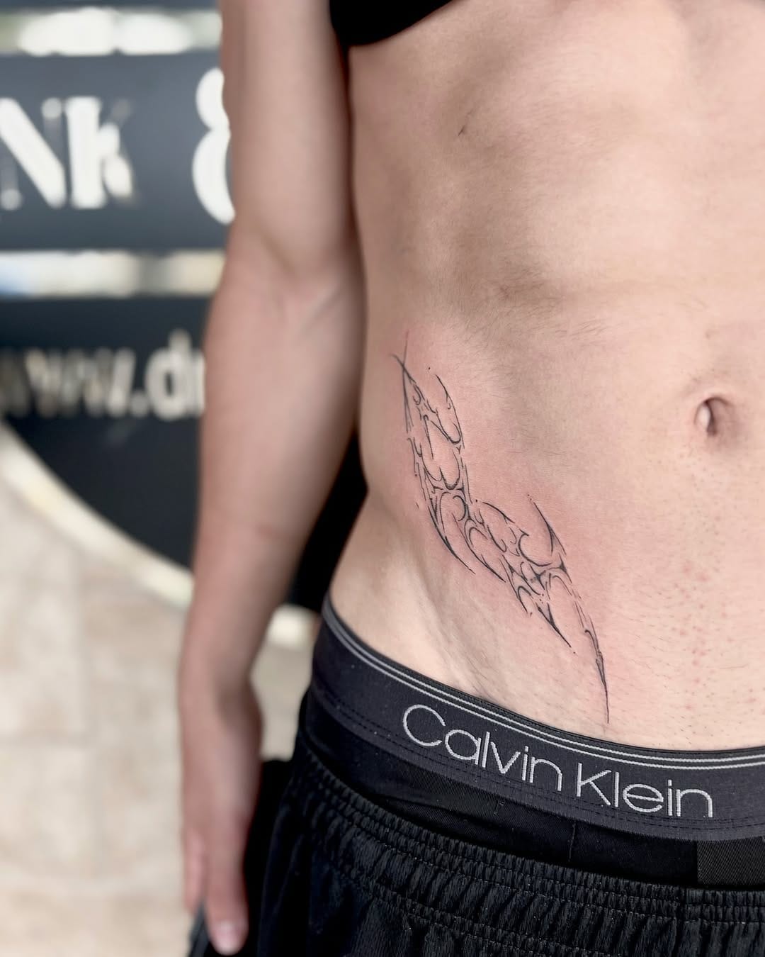 Abstract tribal tattoo on the side of belly