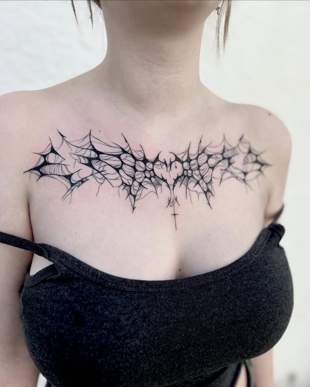 Cybersigilism tattoo on chest with the cross and heart and spiderweb