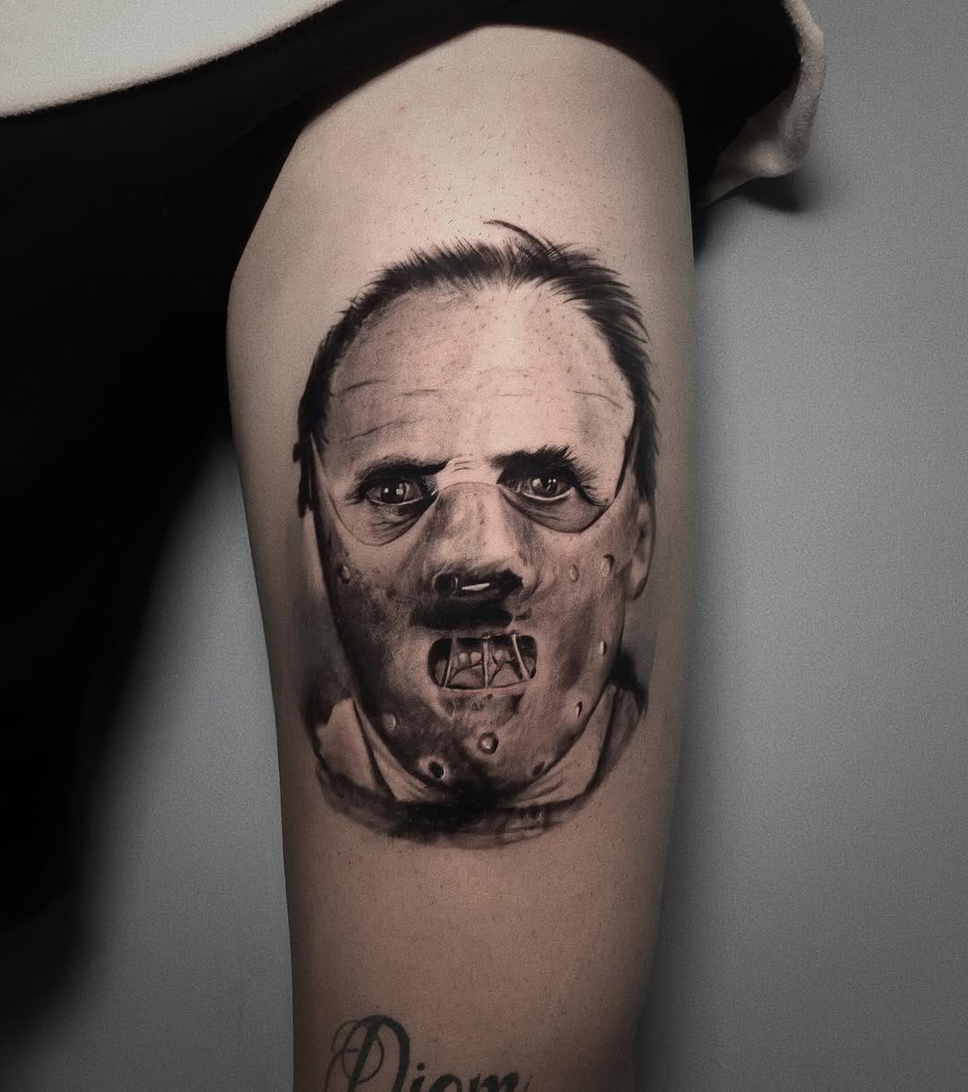 Black And Gray Hannibal Lecter Portrait Tattoo On Thigh