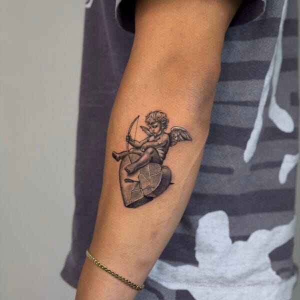 Micro Realistic Cupid With A Broken Heart Arm Tattoo